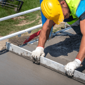 Construction worker leveling concrete on jobsite