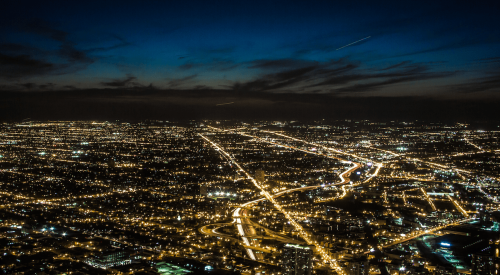 Light pollution shown in aerial nighttime view of a city and suburbs