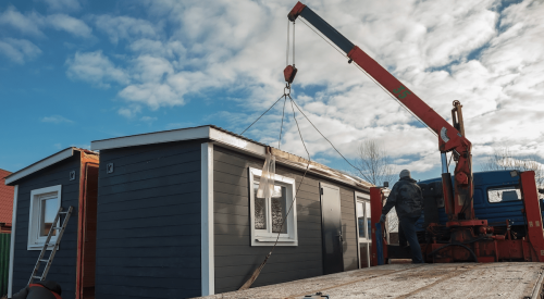 Modular home being delivered to the jobsite by truck