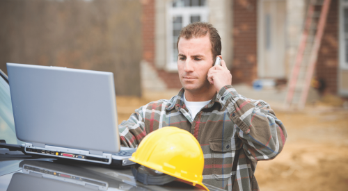 Construction site supervisor on phone at jobsite