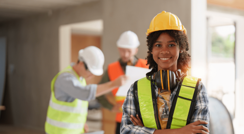 Young woman on construction site wearing yellow hardhat