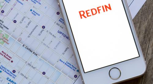 Redfin app open on iPhone next to housing market map